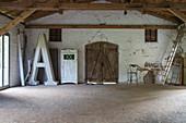 Huge illuminated letter A in old barn with chipboard panels on floor
