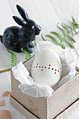 Blown goose egg decorated with pattern of drilled holes