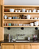 Geschirr und Gläser im Regal über der Spüle in moderner Küche