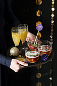 A woman serving a tray of aperitifs at Christmas