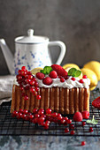 A loaf cake served with cream and summer berries