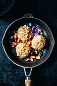 Apricot dumplings with blueberries, peaches and edible flowers