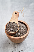 Chia seeds in a wooden bowl and a wooden scoop