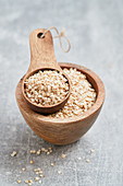 Quinoa flakes in a wooden bowl and a wooden scoop