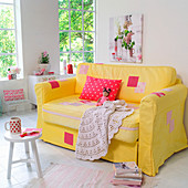 Mit Patchwork aufgemöbeltes, gelbes Sofa im romantischen Wohnzimmer