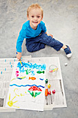 Little boy painting a picture on the back of a jigsaw