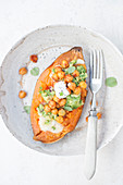 Baked sweet potato stuffed with cheddar cheese, spicy chickpeas, guacamole, yogurt and fresh mint