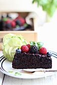 A slice of vegan chocolate cake with berries