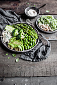 Grün-weiße Buddha Bowl mit Avocado, Brokkoli, Erbsen und gebratenen Shimeji-Pilzen