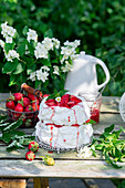 Pavlova mit Erdbeeren auf Gartentisch