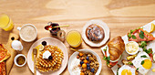 Healthy sunday breakfast with croissants, waffles, granola and sandwiches