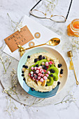 Oatmeal in a bowl with frozen seasonal fruit currants berries kiwi