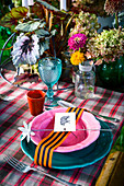Colourful place setting decorating with ribbon, tag and flower