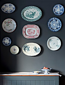 Various old china plates arranged on wall