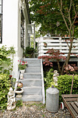 Treppe zur Terrasse im sommerlichen Garten mit Skulpturen