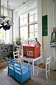 Blue bench in front of dolls' house in country-house-style kitchen-dining room