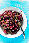 Cherries on an enamel plate with a knife