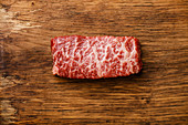 Marmoriertes rohes Steak vom Wagyu-Rind auf Holzuntergrund