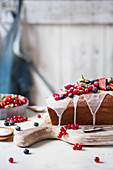 Kastenkuchen mit Zuckerglasur und frischen Sommerbeeren