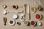 Variety of different handmade wooden and ceramic dishes, bowls and cutlery with seasonings and spices
