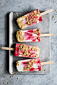 Strawberry rhubarb pie à la mode popsicles have strawberry rhubarb compote layered up with luscious vanilla bean cream and crumbles of pie crust on top