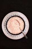 Pink salt flakes on a dark background.