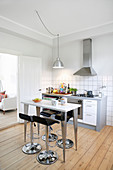 Barstools at high, modern table in simple, classic kitchen-dining room