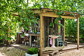 Outdoor-Küche und Outdoor-Bad an der Fassade einer kleinen Holzhütte