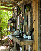 Outdoor kitchen on roofed terrace of small wooden shed