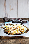 Pizza Bianca with a kale base, herb cream, salmon and mozzarella (keto cuisine)
