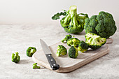Fresh broccoli with a knife on a wooden chopping board