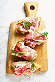 A set of bruschettas with cured meat, pear, blue cheese and ruccola