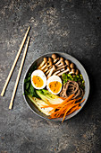 Miso soup with pak choy, carrot, soba pasta, mushrooms, egg and black sesame seeds