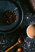 Kaffeestilleben mit gerösteten Kaffeebohnen und Milchkaffee