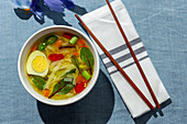 Oriental ramen healthy noodles soup with shiitake, spinach, carrots, eggs and chillies