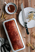 Rectangle loaf of fresh Brioche bread on wooden table with bowl of jam and knife