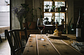 Rotweinflasche und -glas mit Käseplatte auf rustikalem Holztisch