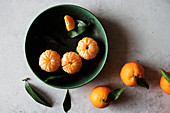 Fresh peeled tangerines and unpeeled fruits with green leaves