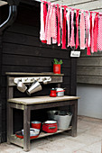Garland of fabric remnants in shades of red above outdoor play kitchen
