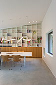 Modernes Arbeitszimmer mit großem Bücherregal, hölzernem Sideboard und minimalistischem Schreibtisch