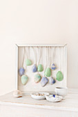 Arrangement of seashells dyed blue and green and hung in deep picture frame
