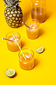 Iced tea with pineapple and coconut syrup in glasses on a yellow background