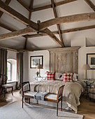 Classic bedroom in beige with exposed roof structure and wooden roof beams
