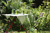 Tablecloth hand-decorated with fern motifs on garden table
