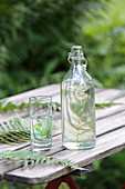 Flasche und Glas mit DIY-Farnmotiv