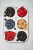 Various fresh berries in a muffin tray