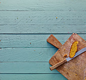 Wooden cutting board with a slice of bread on a rustic wooden surface