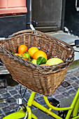 Various citrus fruits in a bicycle basket
