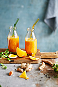 Orange and turmeric ginger drink in bottles