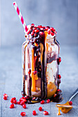 Freak shake with ice cream, caramel sauce and pomegranate seeds